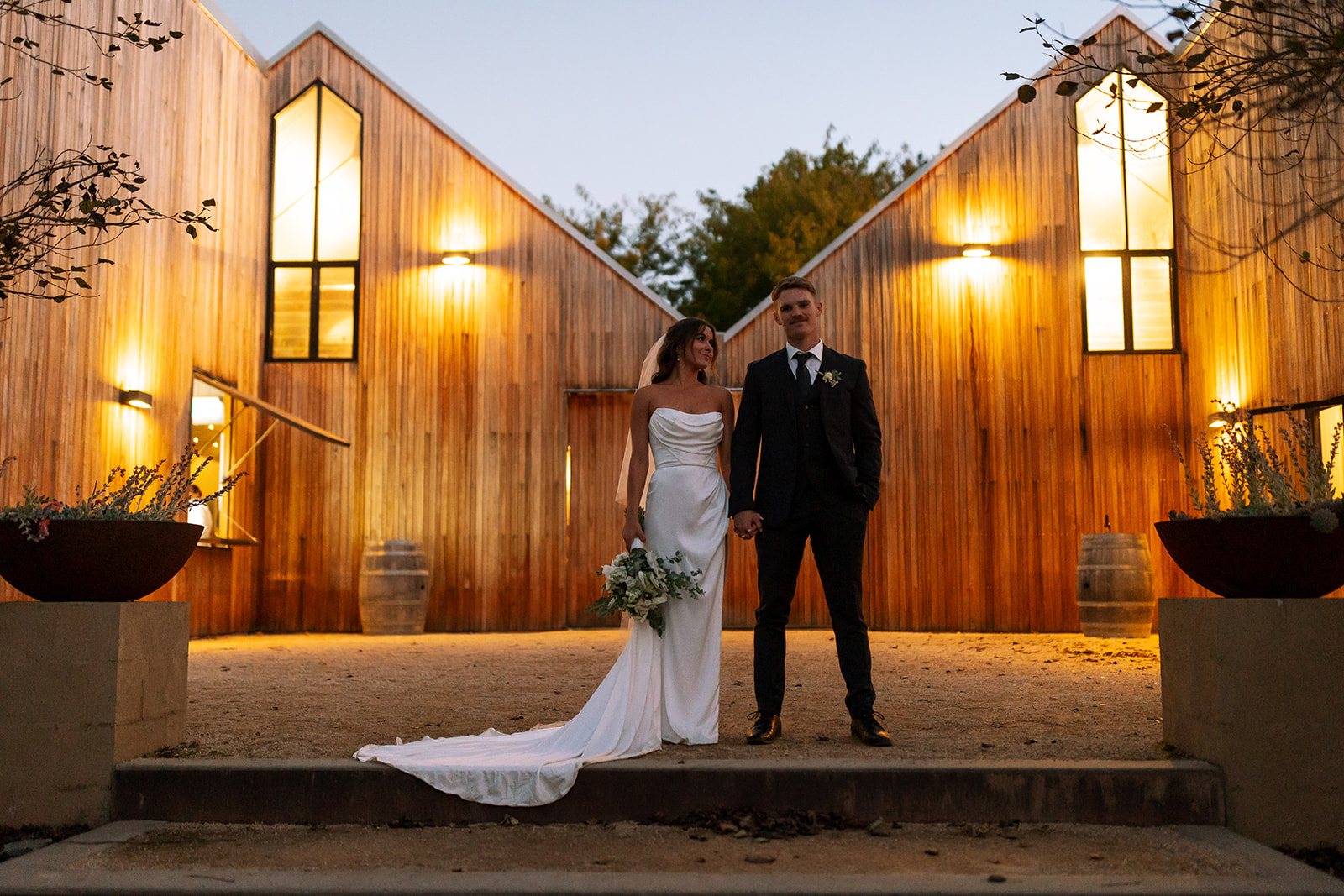 A couple in the courtyard at dusk with the Woodhouse glowing